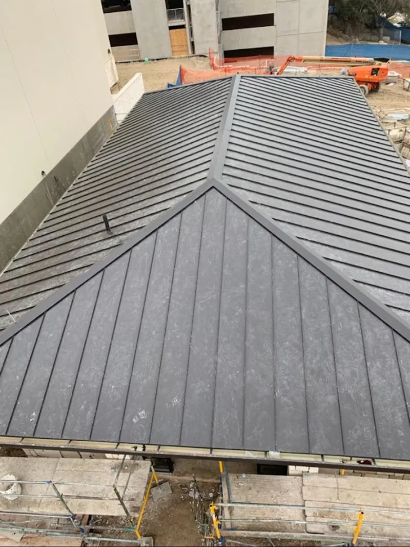 Commercial metal roof construction with crane equipment in East Brunswick